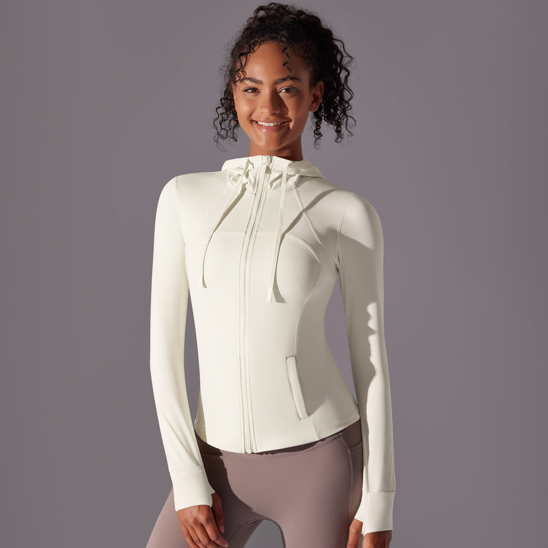 Women wearing stylish Bellactiva activewear—leggings and crop tops—stretching together in a bright, modern studio, highlighting comfort and movement.